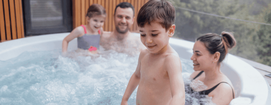 A family relaxes together in a hot tub in their backyard, enjoying quality time and warm water.
