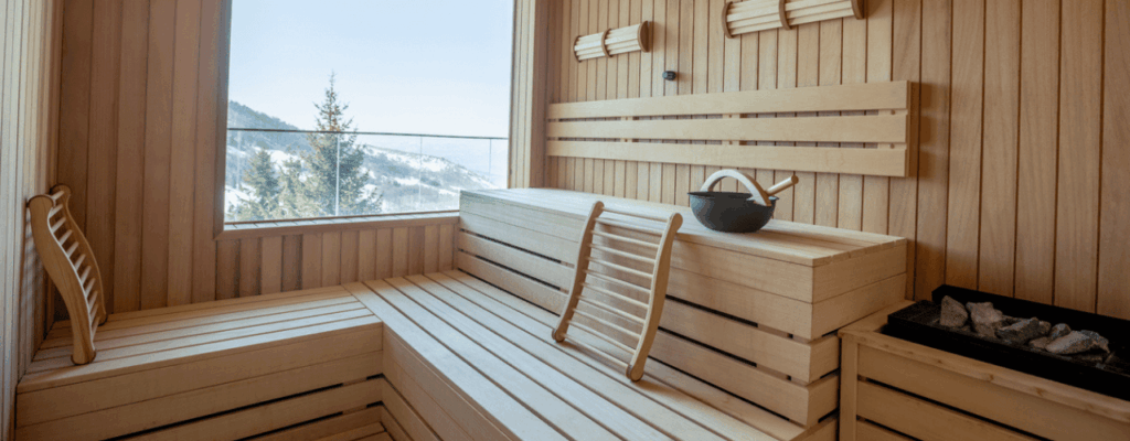 A sauna room featuring wooden benches and a window, creating a warm and inviting atmosphere for relaxation.