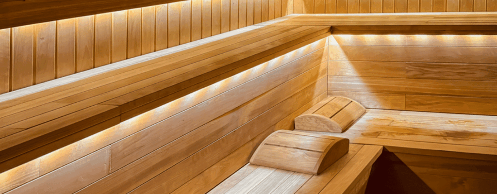 Wooden sauna interior with warm LED lighting and comfortable benches.