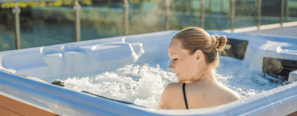 Portrait of young carefree happy smiling woman relaxing at hot tub.