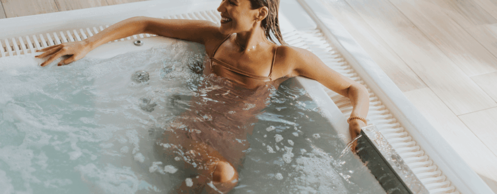 A woman enjoys a moment of relaxation immersed in the soothing waters of a swim spa.