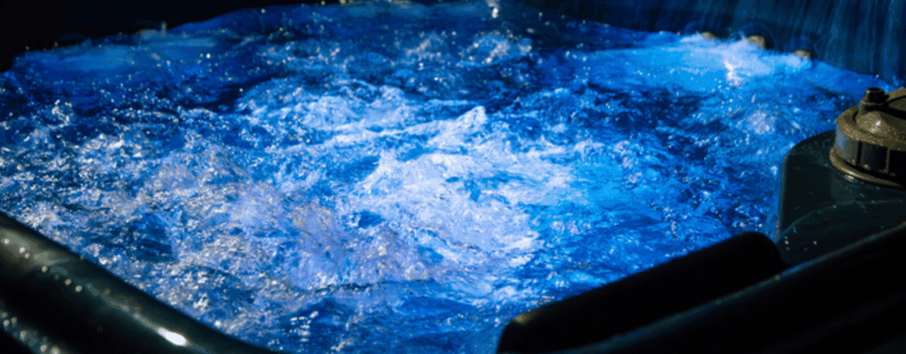 A blue light illuminates a hot tub, creating a serene and inviting atmosphere for relaxation.